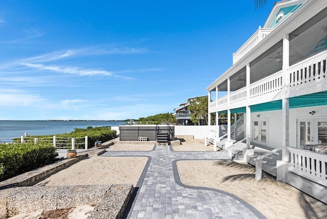 view of patio / terrace featuring a hot tub and a water view