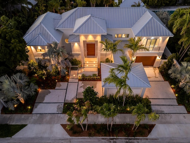 view of front of property featuring a standing seam roof, metal roof, and a balcony