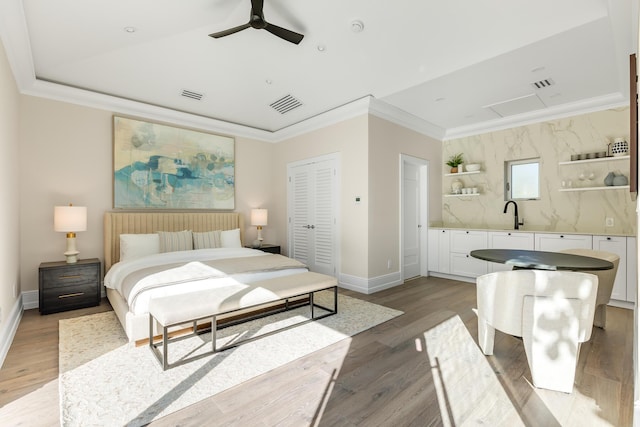 bedroom featuring ornamental molding, light wood-style flooring, and visible vents