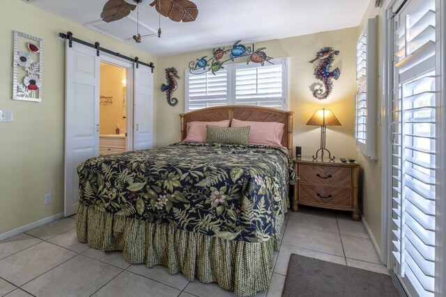 212 Southard St, Key West, FL 33040 - bedroom featuring a barn door, light tile patterned floors, baseboards, ensuite bathroom, and ceiling fan