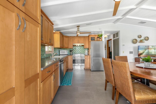 kitchen with backsplash, lofted ceiling with beams, stainless steel appliances, and sink