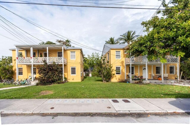 1005-1009 Flagler Ave, Key West, FL 33040 - view of front of home with a front yard, a balcony, and covered porch