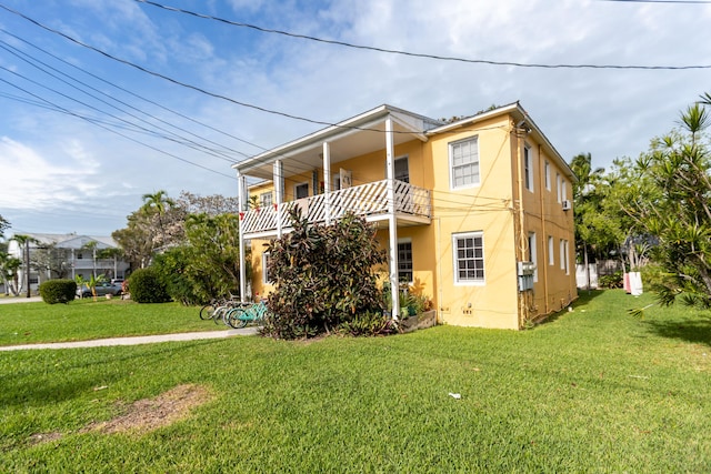 view of front of property featuring a front lawn and a balcony