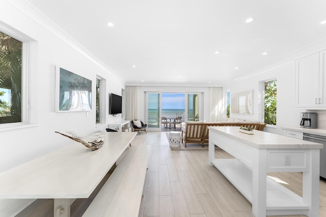 kitchen featuring white cabinetry, a kitchen island, dishwasher, and crown molding