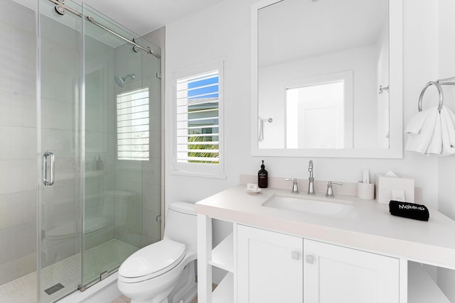 bathroom with vanity, toilet, and a shower with shower door