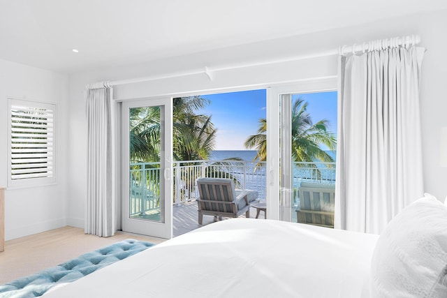 bedroom with a water view and access to outside