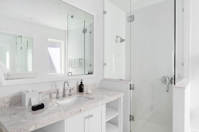 bathroom with a shower with door and vanity