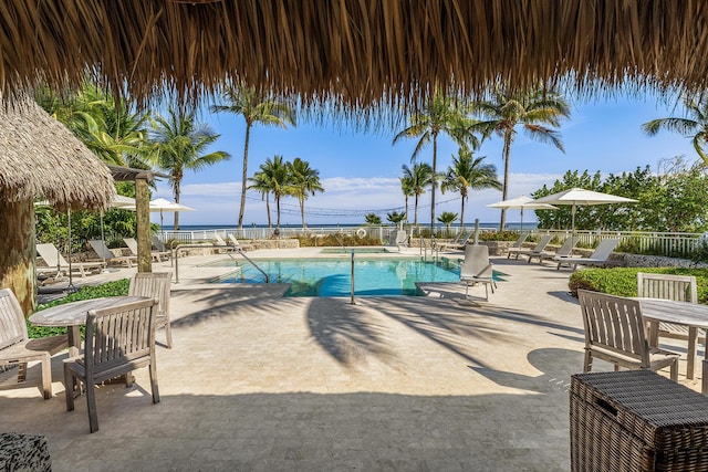 view of pool with a patio and a water view