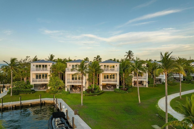 exterior space featuring a water view, a balcony, and a yard