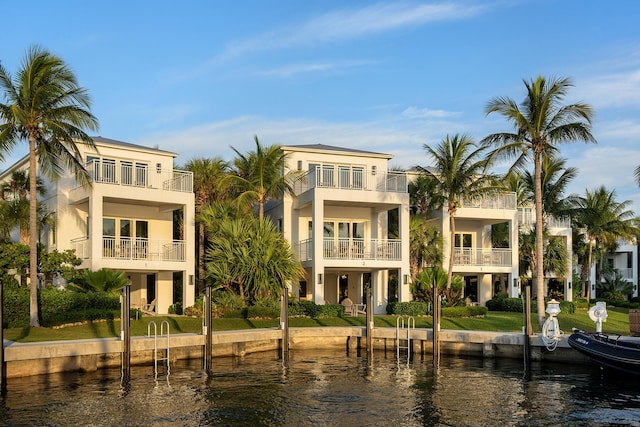 rear view of house featuring a balcony and a water view