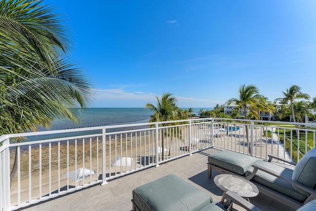 balcony featuring a water view and a view of the beach