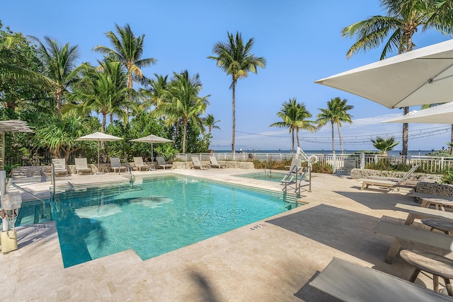 view of swimming pool featuring a water view and a patio area