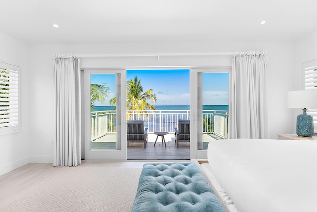 bedroom featuring a water view and access to exterior