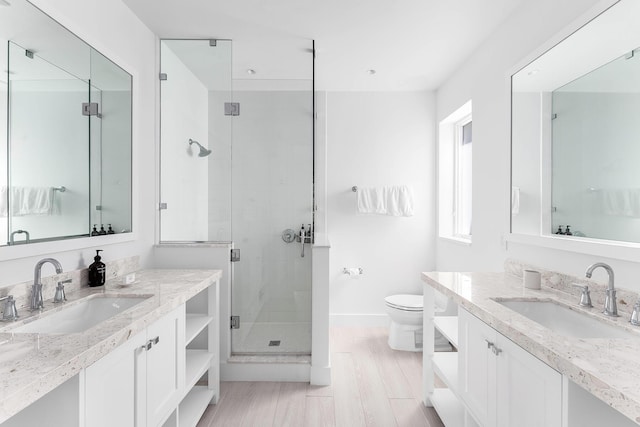 bathroom featuring vanity, hardwood / wood-style flooring, a shower with door, and toilet