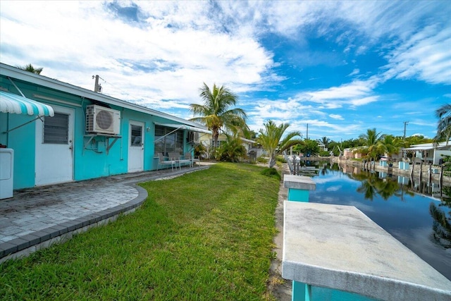 view of yard with washer / dryer, ac unit, a dock, and a water view