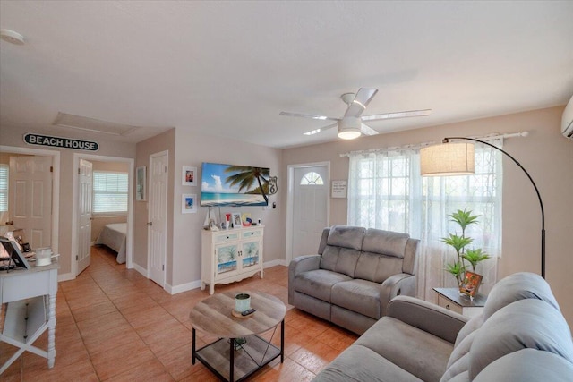 living area featuring light tile patterned flooring, a ceiling fan, and baseboards