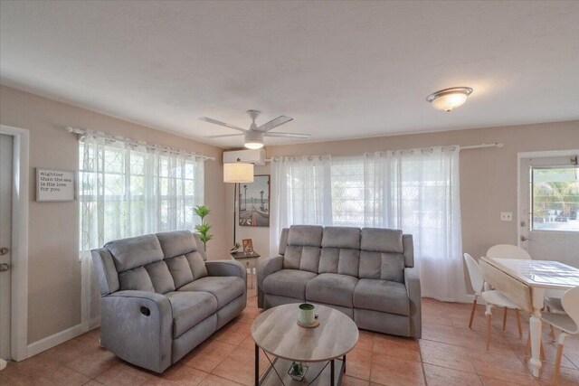 living room featuring baseboards and ceiling fan