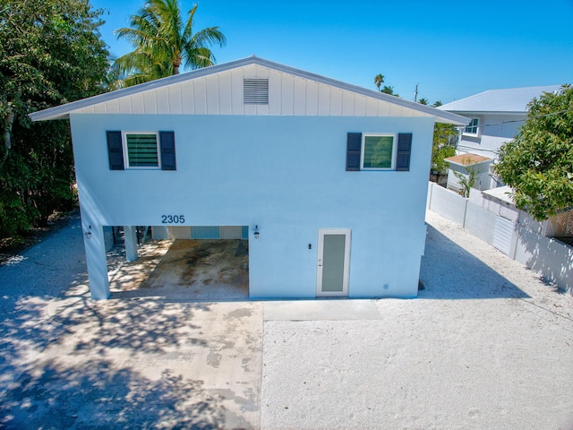 view of front of property featuring concrete driveway and fence