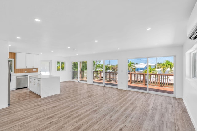 unfurnished living room featuring recessed lighting, plenty of natural light, and light wood finished floors