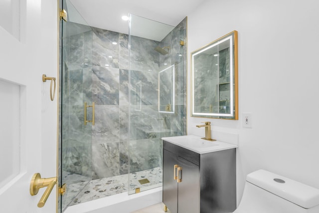 bathroom featuring toilet, a stall shower, and vanity