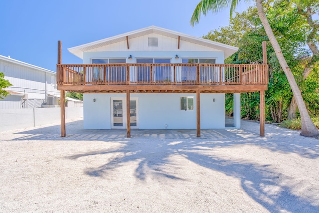 rear view of property featuring fence and a wooden deck