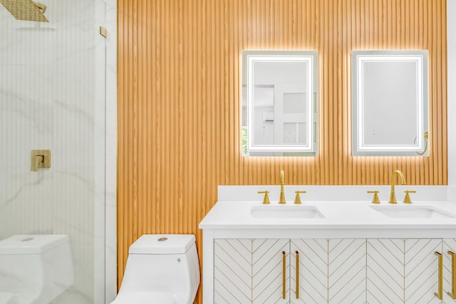 bathroom featuring toilet, a shower with shower door, and a sink