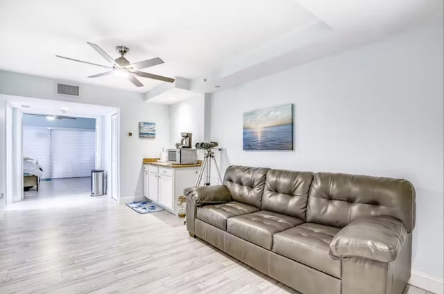 living room with ceiling fan and light hardwood / wood-style flooring