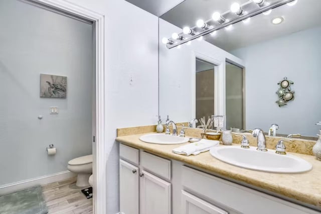 bathroom featuring vanity, hardwood / wood-style floors, and toilet