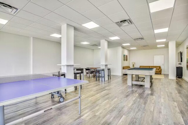 game room featuring pool table, light hardwood / wood-style floors, and a drop ceiling