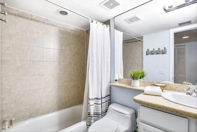 full bathroom with shower / tub combo with curtain, vanity, toilet, and a textured ceiling