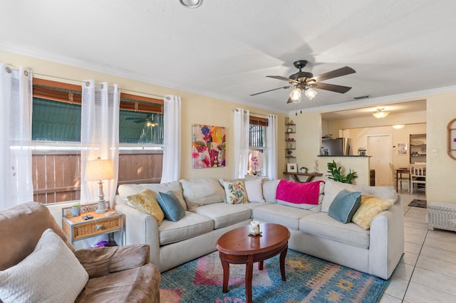 tiled living room with crown molding, radiator heating unit, and ceiling fan