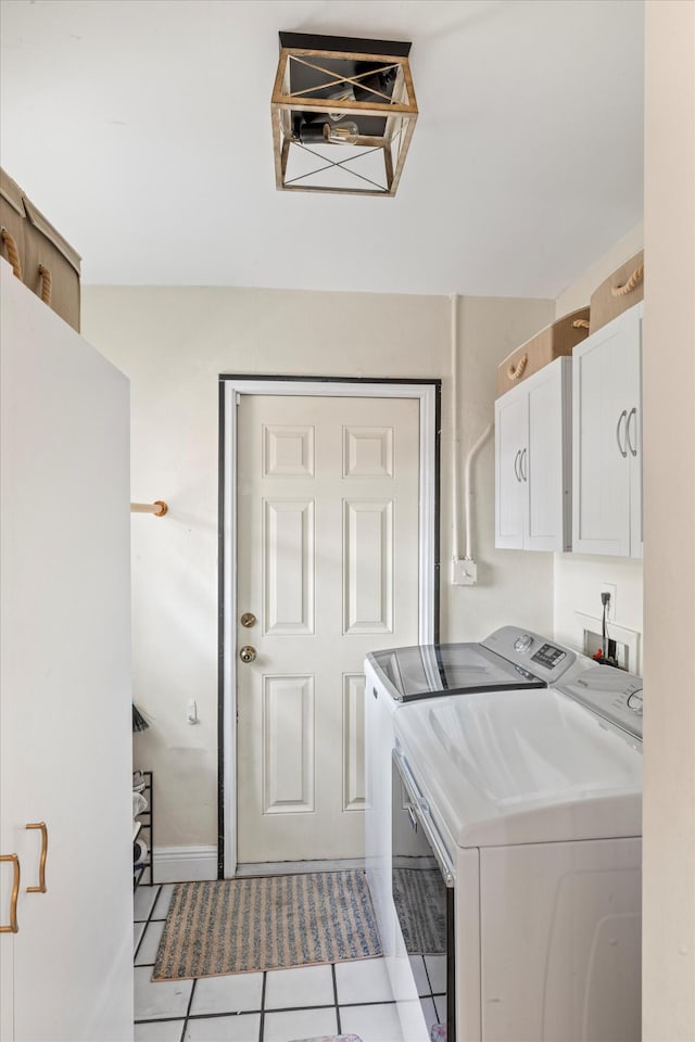 laundry room featuring light tile patterned floors, washer and clothes dryer, and cabinets