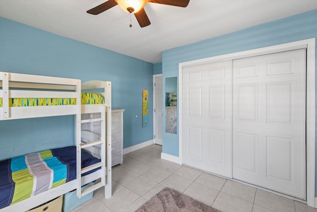 tiled bedroom with ceiling fan and a closet