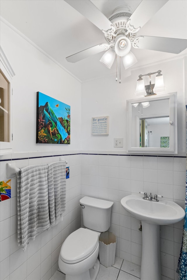 bathroom with sink, ceiling fan, tile patterned flooring, tile walls, and toilet