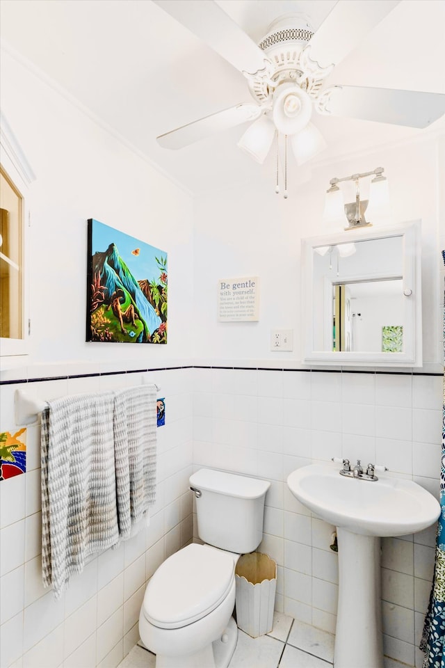 bathroom featuring ceiling fan, toilet, tile patterned flooring, and tile walls