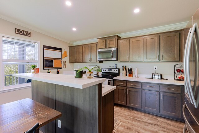 27163 Mariposa Rd, Ramrod, FL 33042 - kitchen with crown molding, appliances with stainless steel finishes, a center island, and light countertops