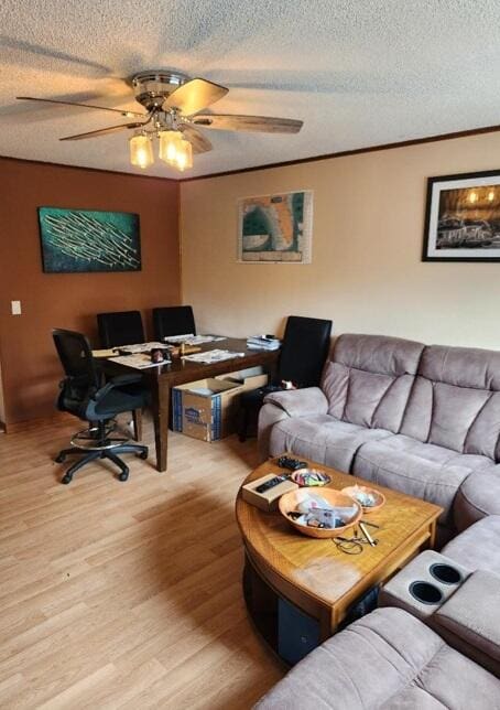 living area with crown molding, a textured ceiling, a ceiling fan, and wood finished floors