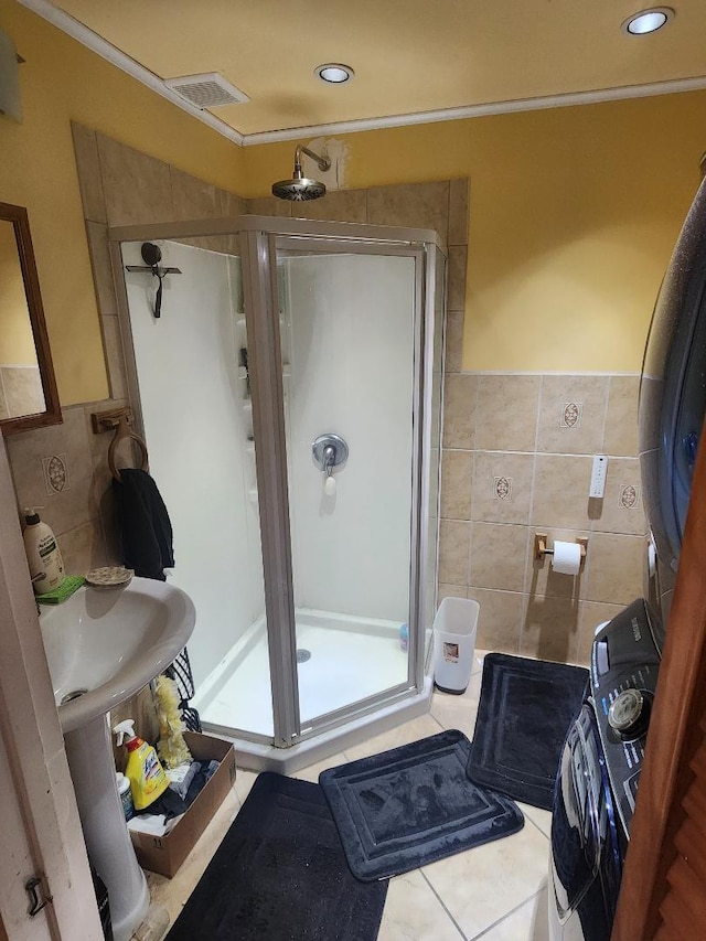 full bathroom featuring a stall shower, tile patterned flooring, visible vents, and tile walls