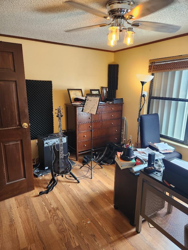 home office with a textured ceiling, ornamental molding, and wood finished floors