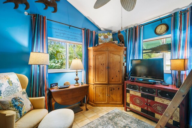 living area featuring ceiling fan, lofted ceiling, and light tile patterned floors