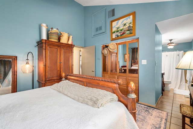 bedroom with light tile patterned floors and high vaulted ceiling