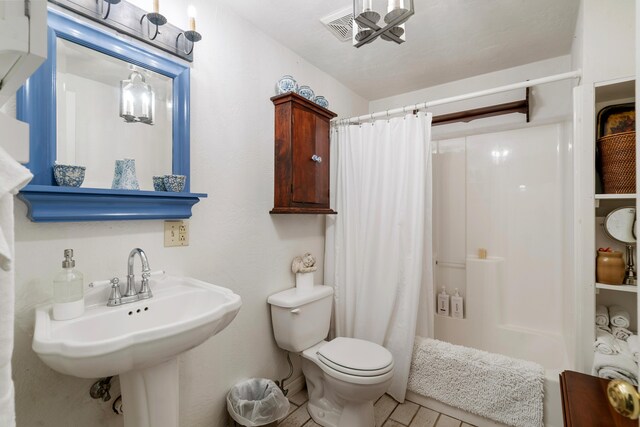 full bathroom with sink, shower / tub combo with curtain, and toilet