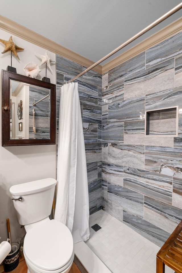 bathroom featuring crown molding, toilet, and walk in shower