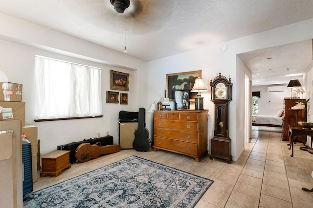 interior space featuring a wall mounted AC and a textured ceiling