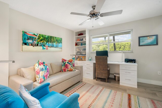 home office with light hardwood / wood-style flooring and ceiling fan