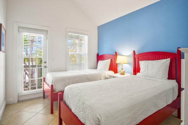 tiled bedroom with access to exterior, multiple windows, and lofted ceiling