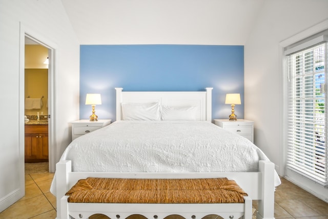 bedroom featuring light tile patterned floors and ensuite bath