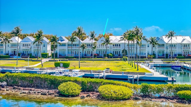 surrounding community with a water view, a residential view, a yard, and a dock