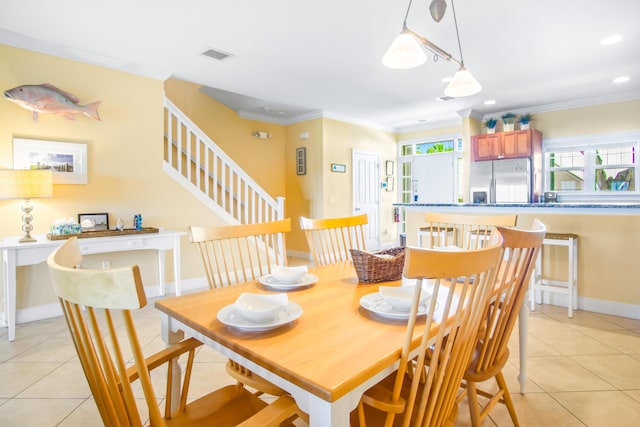 dining area featuring crown molding, light tile patterned floors, visible vents, and stairs