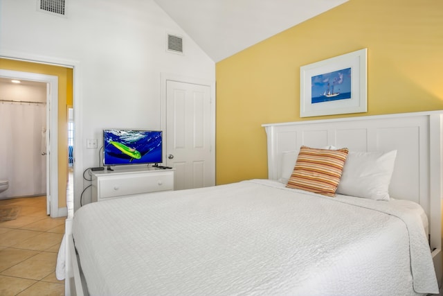 bedroom with light tile patterned floors, vaulted ceiling, and visible vents